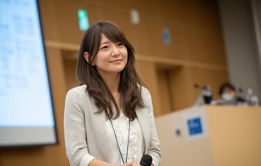 Confident Japanese woman delivers impactful presentation on stage in front of engaged audience during professional seminar