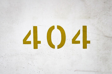 Number 404 error sign super close up. Gold numbers on urban grey concrete wall. Numeral digits symbols.