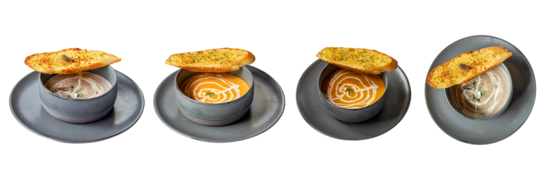 Gourmet Soup Collection: A delicious gourmet soup is exquisitely presented in a set of four grey bowls, each adorned with a slice of golden-brown.