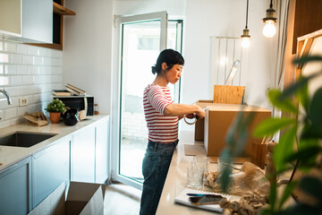 Woman packing boxes in kitchen