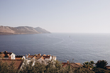 A picturesque coastal view of Kas, Turkiye, Mediterranean Sea. White houses with red-tiled roofs,...