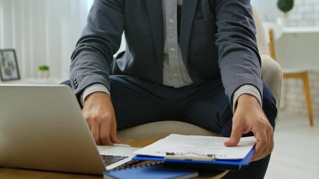 Man Writing Notes on Blue Clipboard in Office Setting