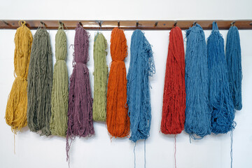 Silks thread hangs from a loom at the Turkish silk carpets workshop in  Avanos