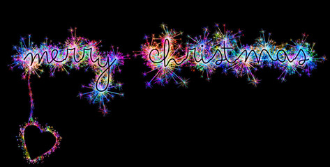 Kolorowe zimne ognie i fajerwerki układające się w kształt świątecznych życzeń: Merry Christmas w języku angielskim.