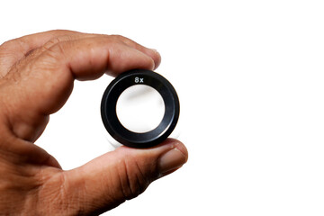 hand picked photographic loupe on a white surface Magnification 8X  isolated on white background.