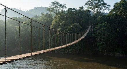 Obraz premium Wooden suspension bridge spanning a misty river, lush jungle backdrop