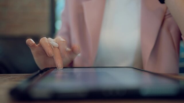 Creative female content creator writing or designing with stylus pen on digital tablet, online media concept