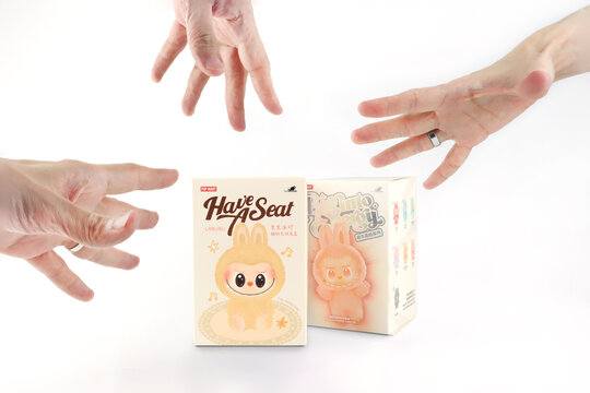 art toys Labubu key chain collection from Pop Mart blind box collectable cute toys display on white shelf background at Pop mart flagship store during new release promotion event labubu macaron doll