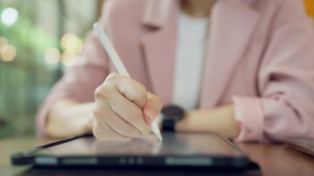 Creative female hand using stylus pen for graphic design on tablet screen, concept of digital illustration and creativity