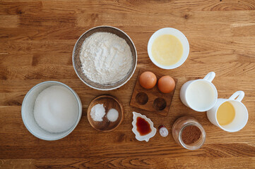 Baking pastry or cake ingredients, brown sugar, butter, flour, eggs and milk top view with copy space