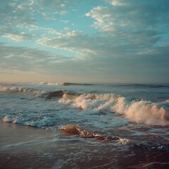 Scenic Ocean Waves Crashing on Sandy Beach Under Cloudy Sky During Sunset