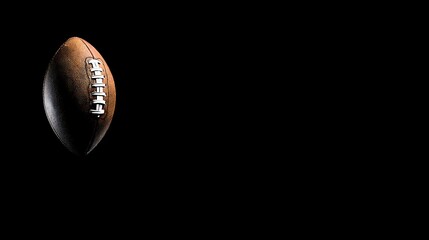 American Football Brown Leather Ball with White Laces Isolated on Black Background