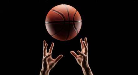 Basketball above reaching hands on black, dramatic contrast and directional light, sharp ball texture, shallow depth of field, energetic minimal sports branding