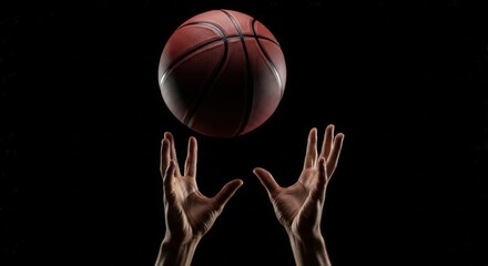 Basketball above reaching hands on black, dramatic contrast and directional light, sharp ball texture, shallow depth of field, energetic minimal sports branding
