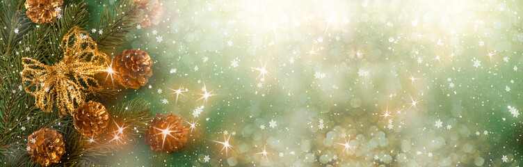 Christmas background with fir tree branch, golden bow and cones for decoration. New Year winter holidays concept with decor in green and gold color, shining stars and copy space, snowy top view banner