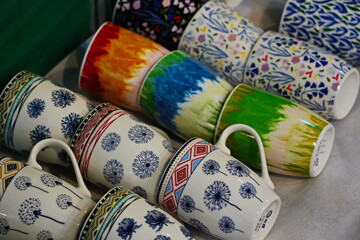 Various ceramic mugs are displayed on the table.