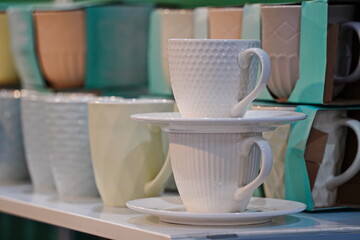 Various ceramic mugs are displayed on the table.