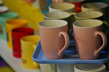 Various ceramic mugs are displayed on the table.