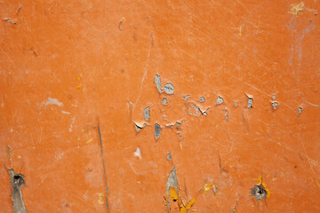 Orange painted metal surface with scratches and cracks. Abstract background for design.