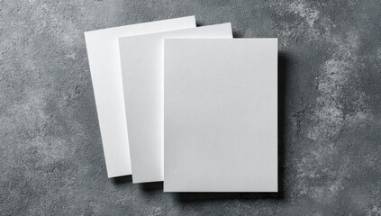 Three blank white brochures stacked on a textured gray surface
