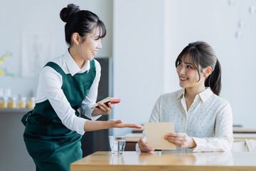 カフェで接客する若い女性