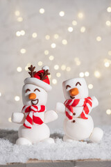Two marshmallow snowmen with red scarves and hats