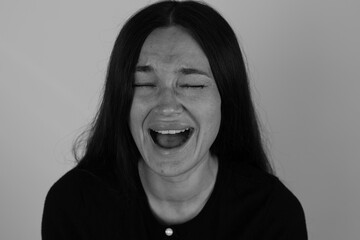 Woman in deep laughter, eyes shut, mouth wide open