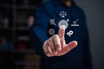 Businessman hand pressing digital legal icons with target, law, justice, and technology symbols, representing legal innovation, compliance, and digital business solutions.