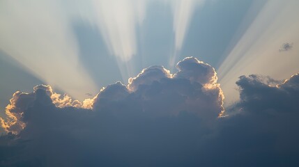 Sunbeams pierce through a dramatic, light-filled cumulus cloud formation, creating a striking celestial scene.