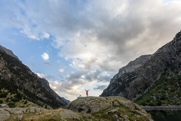 A person is standing on a rocky mountain top