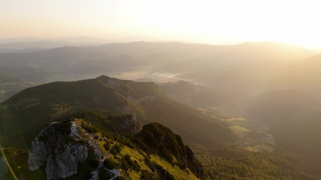 An aerial ideo slow dolly-out motion, revealing a majestic mountain peak and its surroundings. 