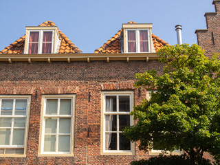 Traditional Dutch brick houses with dormer windows and summer greenery, Leiden heritage travel