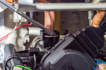 A service center technician repairs a heating boiler heat exchanger, close-up
