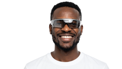 An African man wearing futuristic glasses is smiling at the camera
