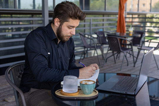 Man working on laptop at table with coffee