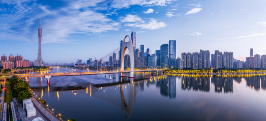 Modern bridge and city financial district skyline at sunrise in Guangzhou.