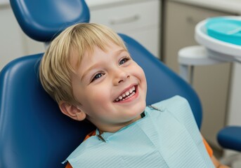 Joyful young boy with bright smile relaxes in a blue dental chair wearing a protective bib during a checkup