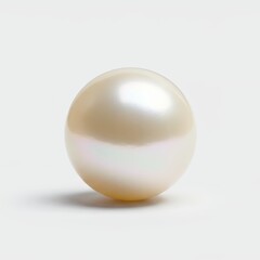 A lustrous, round pearl rests on a plain white surface, showcasing its smooth, pearly texture and subtle color variations.