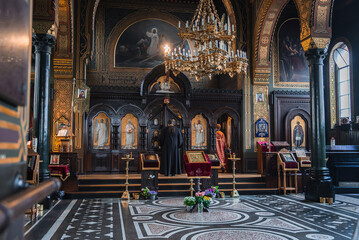 Obraz premium The image shows a richly decorated church interior in Copenhagen, Denmark, with a golden chandelier, religious icons, mosaic floors, and arched windows.