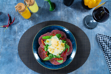 Beef Carpaccio with Parmesan on Elegant Blue Plate