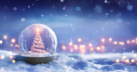 Fototapeta na wymiar Christmas Tree In Snowglobe On Snow In Night With Shiny Star And In Winter Background - Festive Bokeh Lights