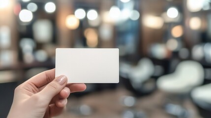 Hand holding a blank business card in a salon setting