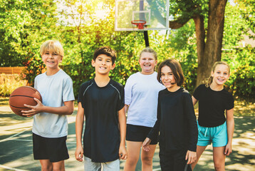 teens in sportswear playing basketball game outside together