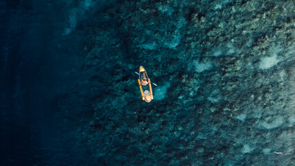 Swimming on kayak in blue sea. Drone view