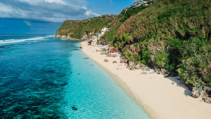 Tropical sandy beach with quiet ocean in Bali. Aerial view of popular location Melasti beach