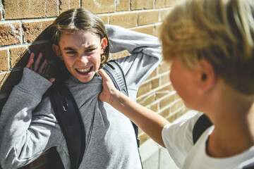 sad boy Bullying in Schoolyard brick wall