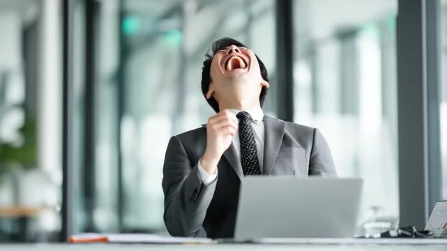 Business Professional's Overjoyed Moment: A businessman, brimming with elation and triumphant delight, expresses genuine joy in an office setting.
