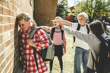 sad girl Bullying in Schoolyard with other student have some intimidation attitude