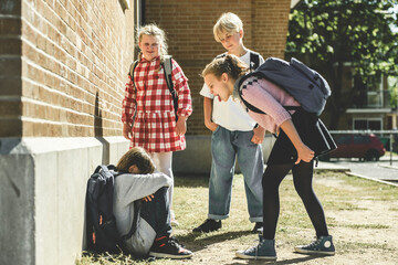 sad moment Elementary Age Bullying in Schoolyard. childs bully child boy