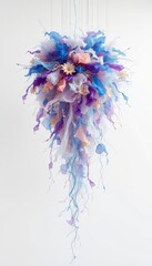 Obraz premium Hanging mobile of flowing colors and delicate flowers with thin branch-like structures on an clean, off-white background